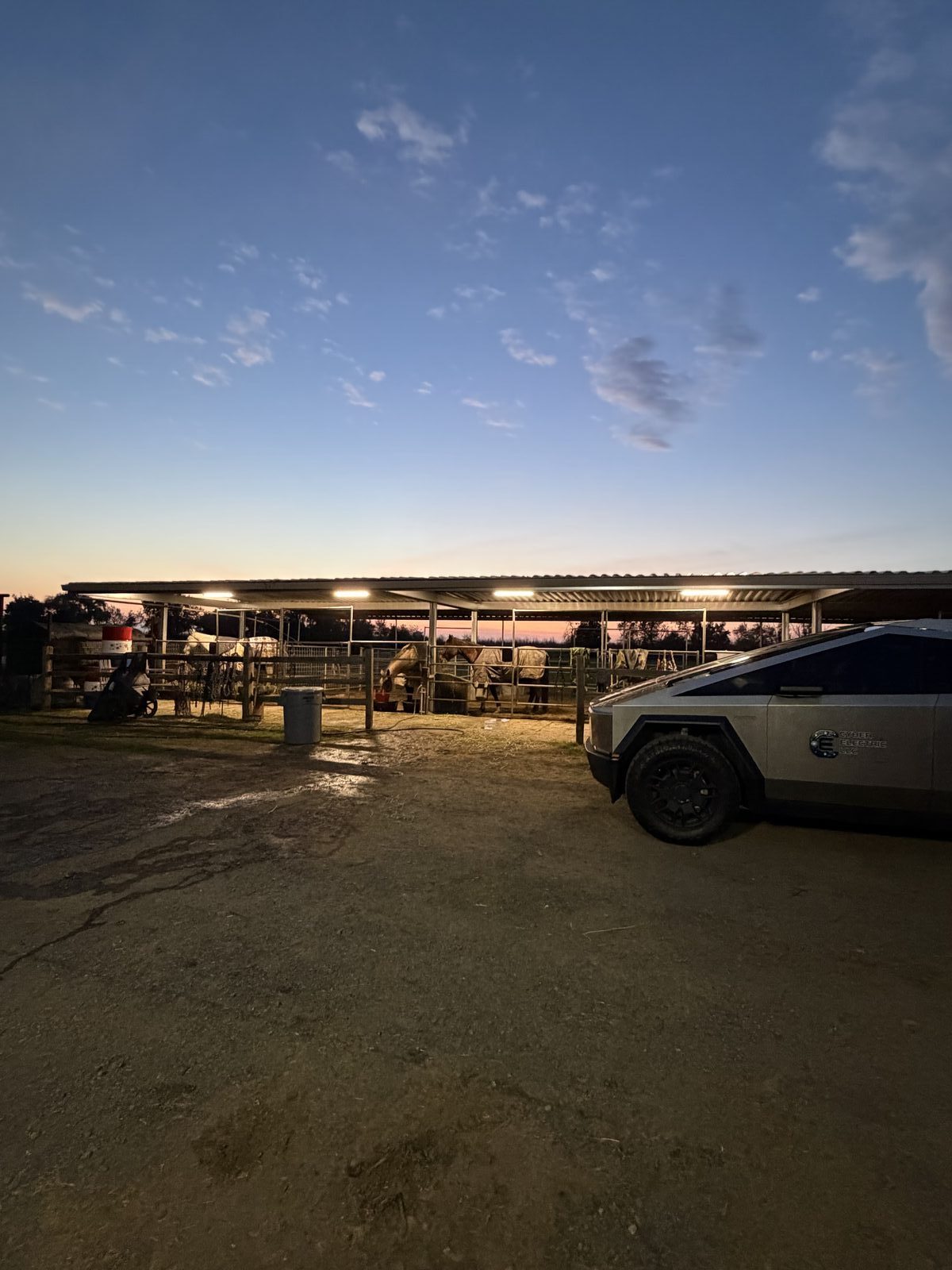Horse stable with new LED lighting glowing at dusk — Cyber Electric LLC Cybertruck on site, Central Valley CA