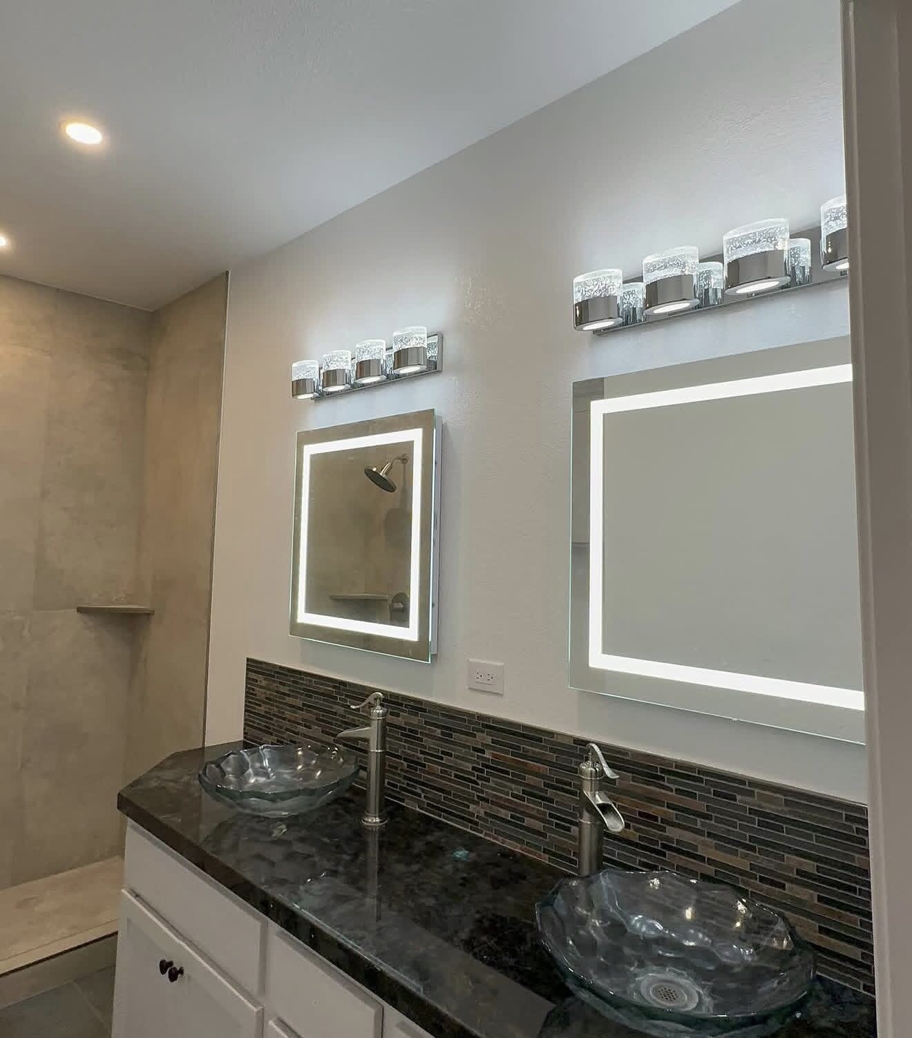 Master bathroom with dual backlit LED mirrors, chrome vanity bars, recessed lighting, and glass vessel sinks — Cyber Electric LLC